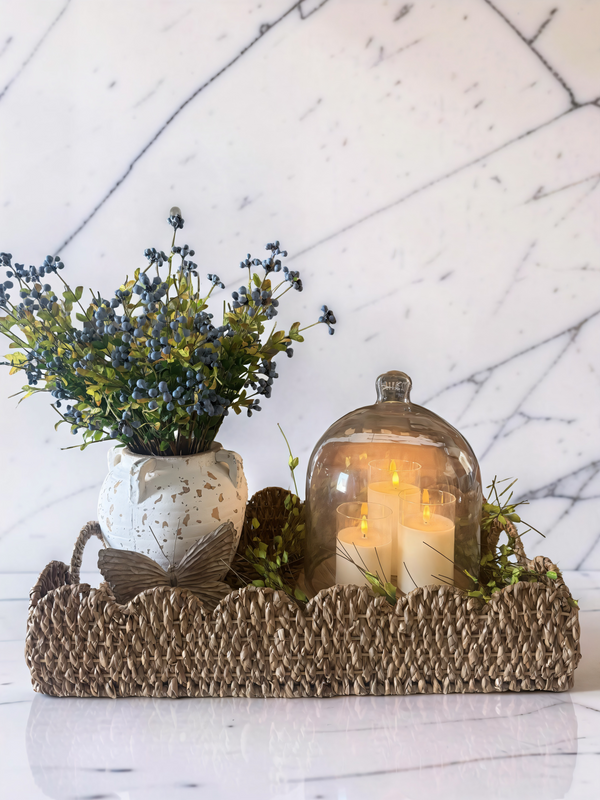 Soft textures, warm glow, and a touch of natureThis simple tray moment brings everything together-woven texture, soft greenery, and a cozy candlelight glow under glass. Effortless styling that feels calm and collected.A reminder that beautiful doesn't have to be complicated